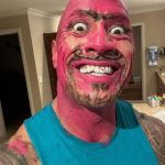 The Rock covered in pink makeup making a funny facial expression
